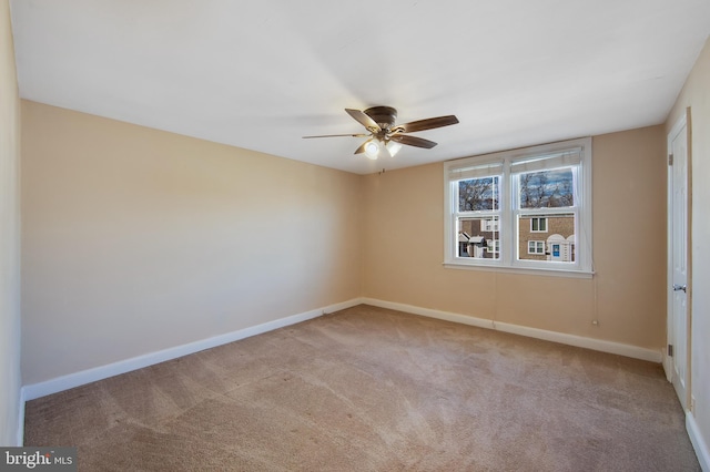 spare room featuring light colored carpet and ceiling fan