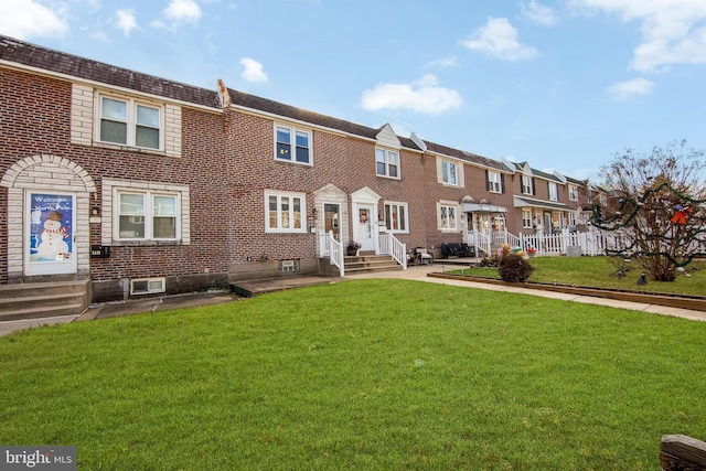 townhome / multi-family property featuring a front lawn