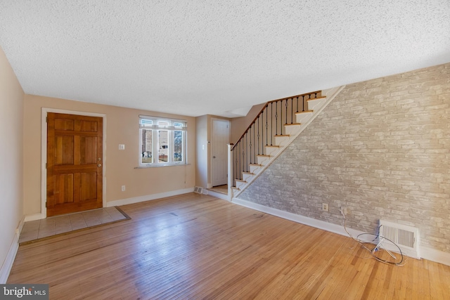 foyer with a textured ceiling and light hardwood / wood-style floors