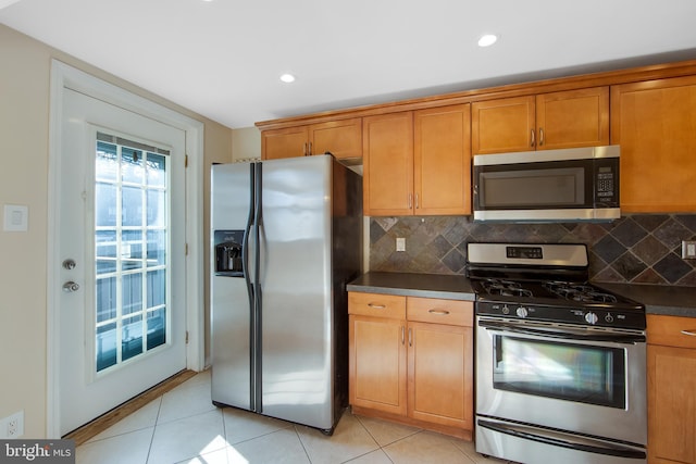 kitchen with stainless steel appliances, tasteful backsplash, and light tile patterned flooring