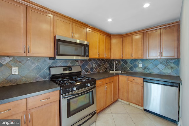 kitchen with decorative backsplash, light tile patterned floors, sink, and appliances with stainless steel finishes