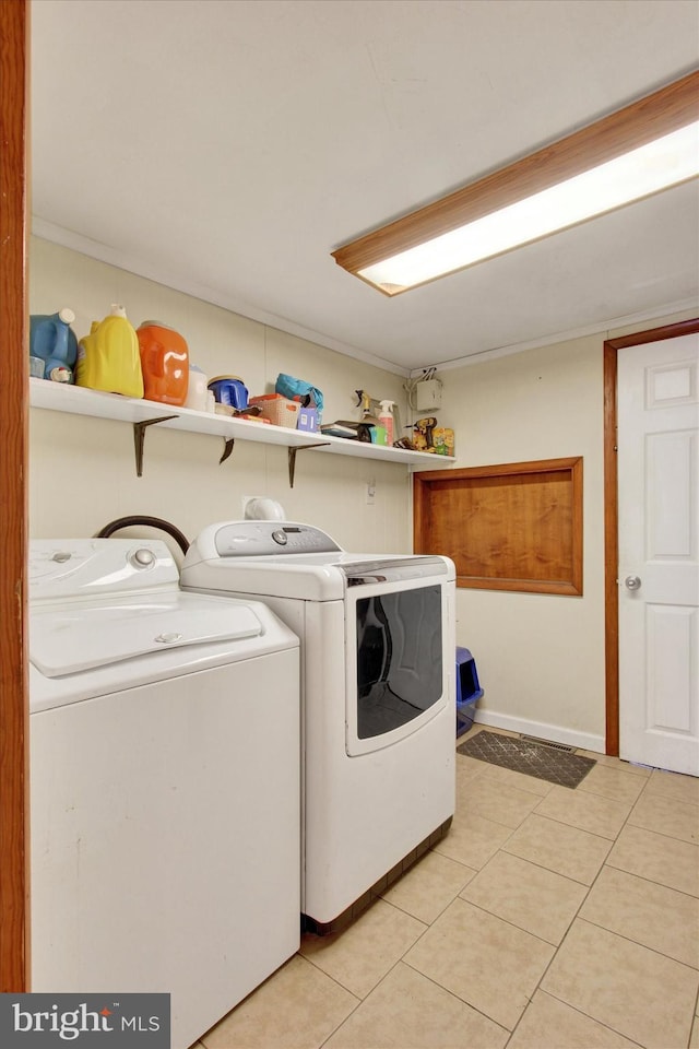 clothes washing area with independent washer and dryer and light tile patterned floors