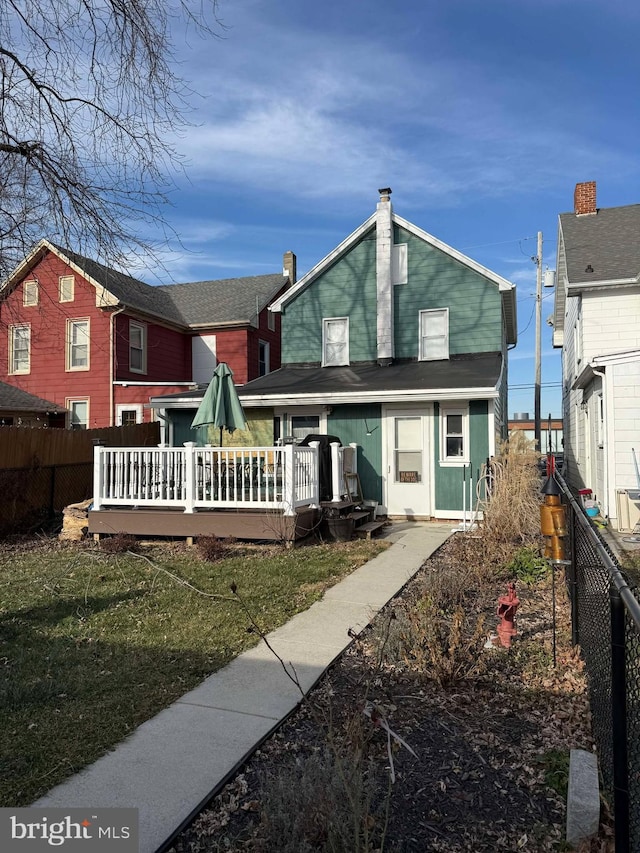 rear view of property with a lawn and a wooden deck