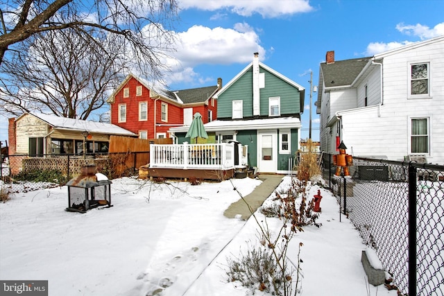 snow covered house featuring a deck