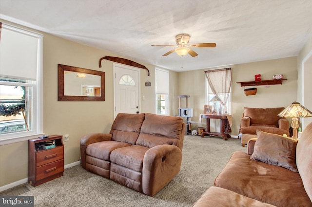 living room featuring ceiling fan, light colored carpet, and a wealth of natural light