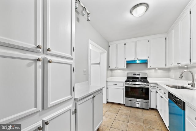 kitchen with dishwashing machine, a sink, white cabinets, light countertops, and stainless steel gas stove