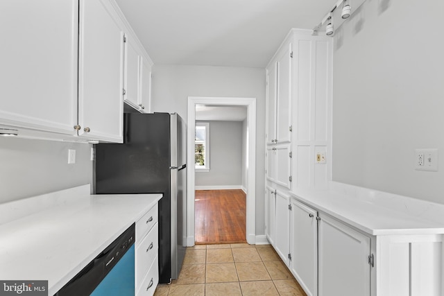 kitchen featuring light tile patterned floors, light countertops, white cabinetry, and dishwashing machine