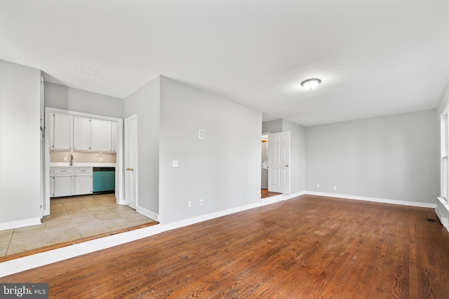 unfurnished living room featuring light wood finished floors and baseboards