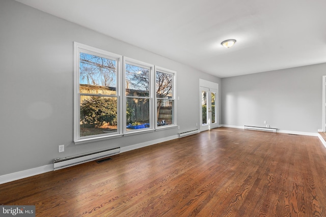 interior space featuring baseboard heating, wood finished floors, and baseboards