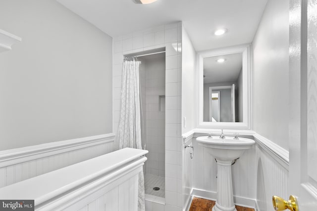 full bathroom with a stall shower and a wainscoted wall