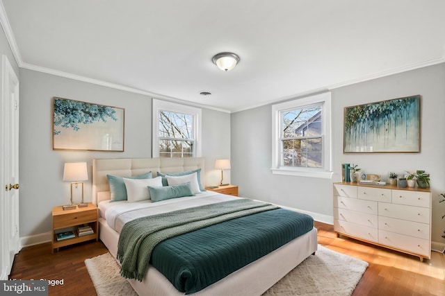 bedroom with dark wood-style floors, baseboards, and crown molding