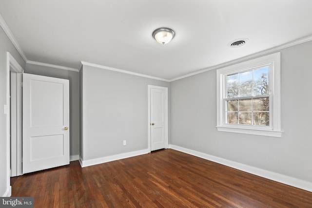 unfurnished bedroom featuring crown molding, visible vents, dark wood finished floors, and baseboards