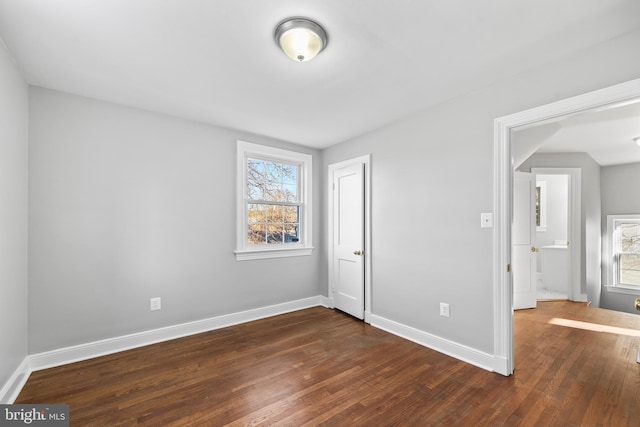 unfurnished bedroom featuring dark wood finished floors and baseboards