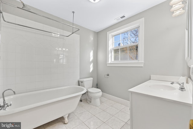 bathroom with toilet, visible vents, baseboards, a freestanding bath, and tile patterned floors