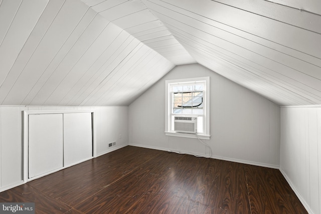 additional living space featuring vaulted ceiling, dark wood-type flooring, cooling unit, and visible vents