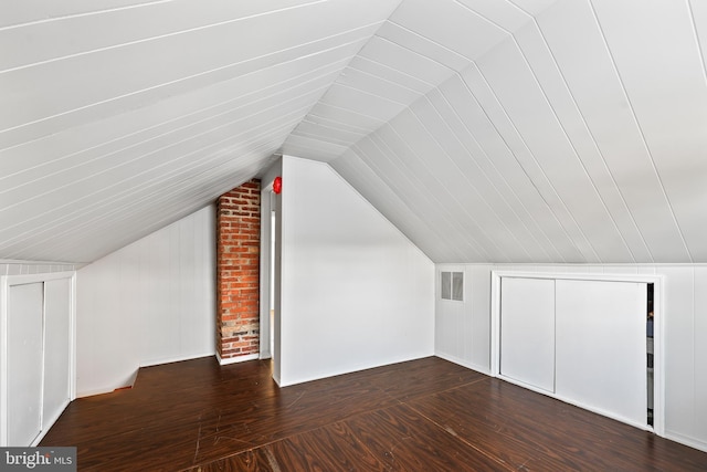 bonus room featuring dark wood-style floors, visible vents, and vaulted ceiling