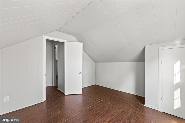 additional living space with dark wood-style flooring and vaulted ceiling