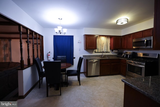 kitchen featuring decorative light fixtures, sink, stainless steel appliances, and a notable chandelier