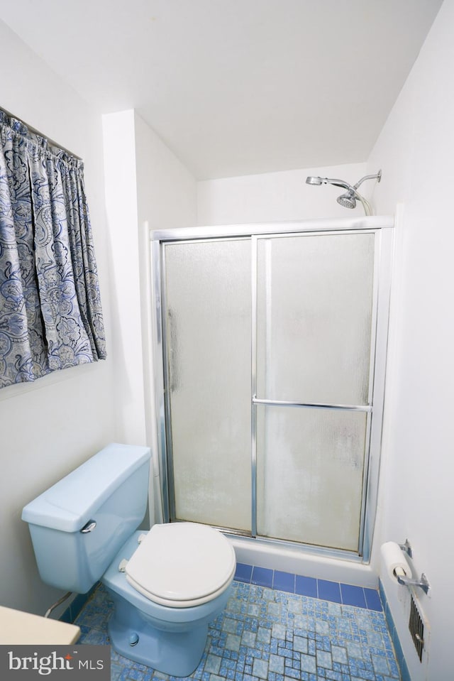 bathroom with toilet and an enclosed shower