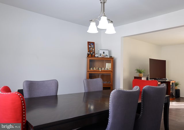 dining space featuring hardwood / wood-style floors and a chandelier