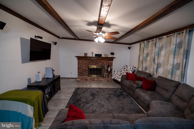 living room with wood-type flooring, ceiling fan, and a brick fireplace