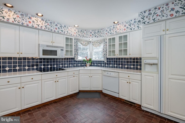 kitchen featuring backsplash, white cabinetry, sink, and white appliances