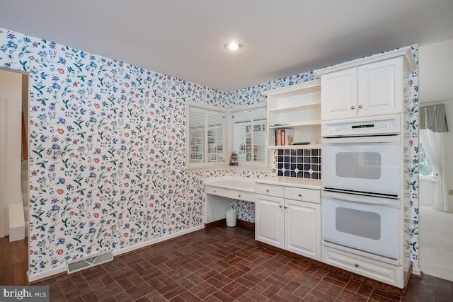 kitchen featuring white cabinets and white double oven