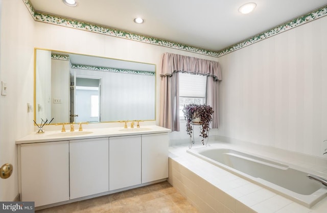 bathroom featuring vanity and tiled tub