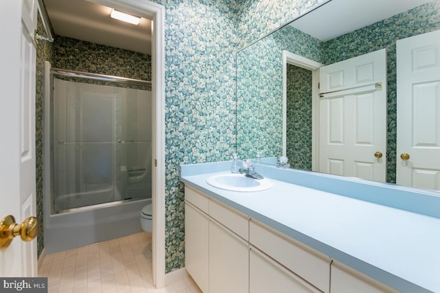 full bathroom featuring vanity, toilet, and combined bath / shower with glass door