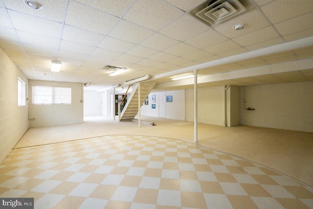 basement featuring carpet flooring and a paneled ceiling