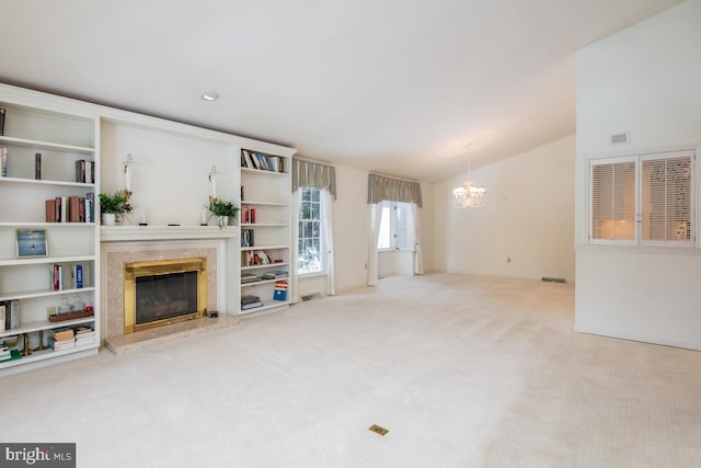 living room featuring carpet flooring, a premium fireplace, a chandelier, and vaulted ceiling