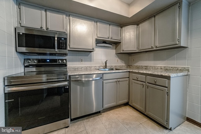 kitchen featuring gray cabinets, light tile patterned flooring, sink, and appliances with stainless steel finishes