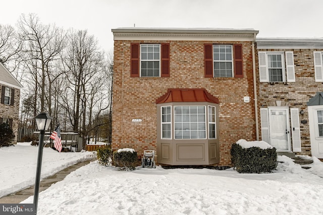 view of snow covered rear of property