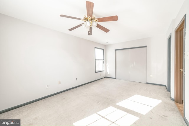 unfurnished bedroom with ceiling fan, a closet, and light colored carpet