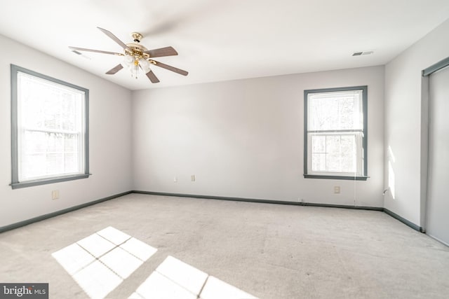 unfurnished room with ceiling fan and light carpet