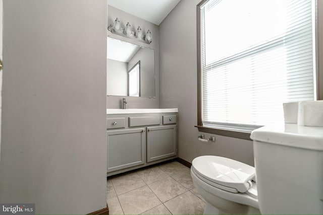 bathroom with tile patterned floors, toilet, a wealth of natural light, and lofted ceiling