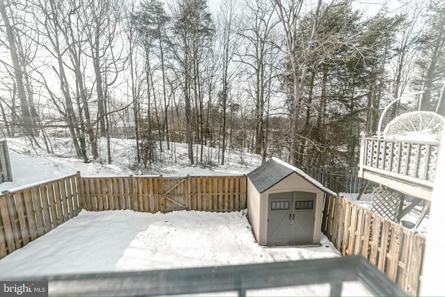 snow covered deck featuring a storage shed