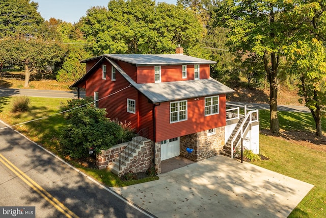 view of side of home featuring a garage and a lawn