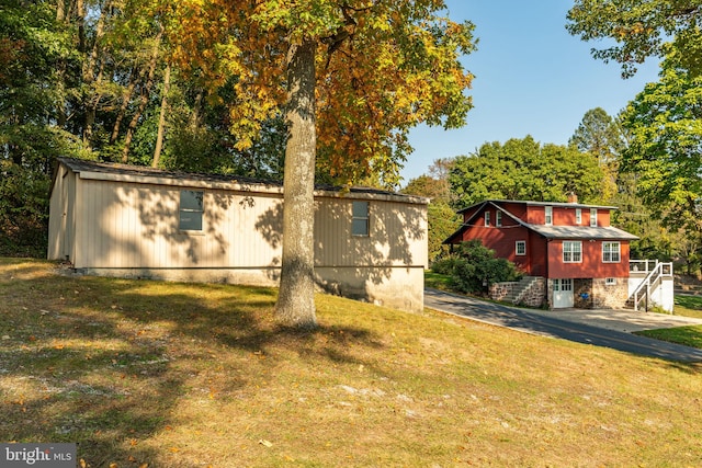 exterior space featuring an outdoor structure and a lawn