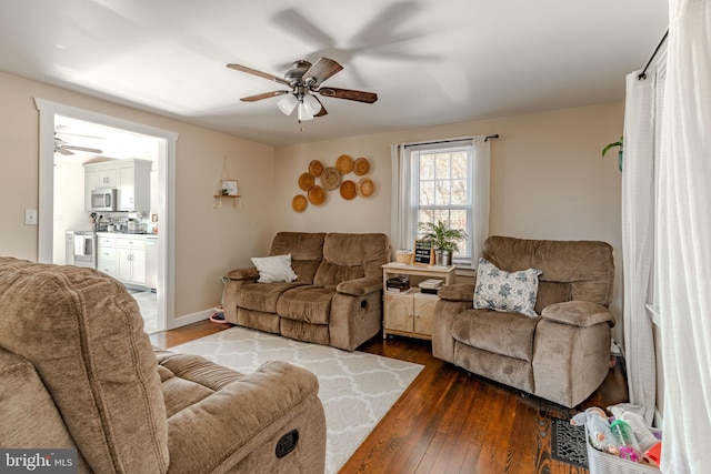 living room featuring ceiling fan and dark wood-type flooring