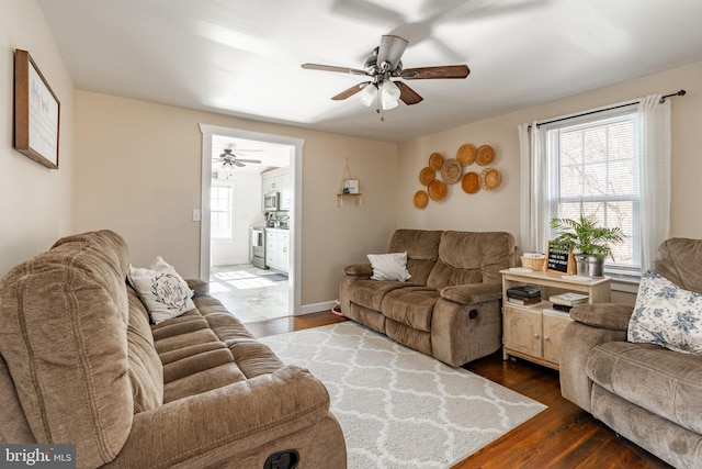 living room with dark hardwood / wood-style flooring and ceiling fan