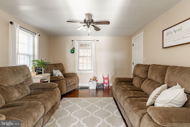 living room featuring ceiling fan and dark wood-type flooring