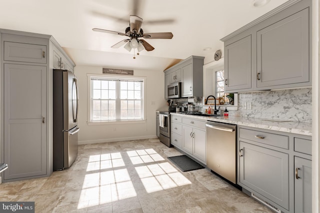 kitchen with gray cabinetry, sink, ceiling fan, tasteful backsplash, and stainless steel appliances