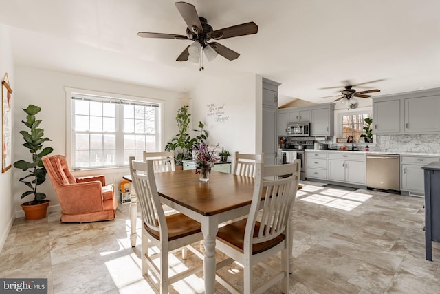 dining space featuring ceiling fan and sink