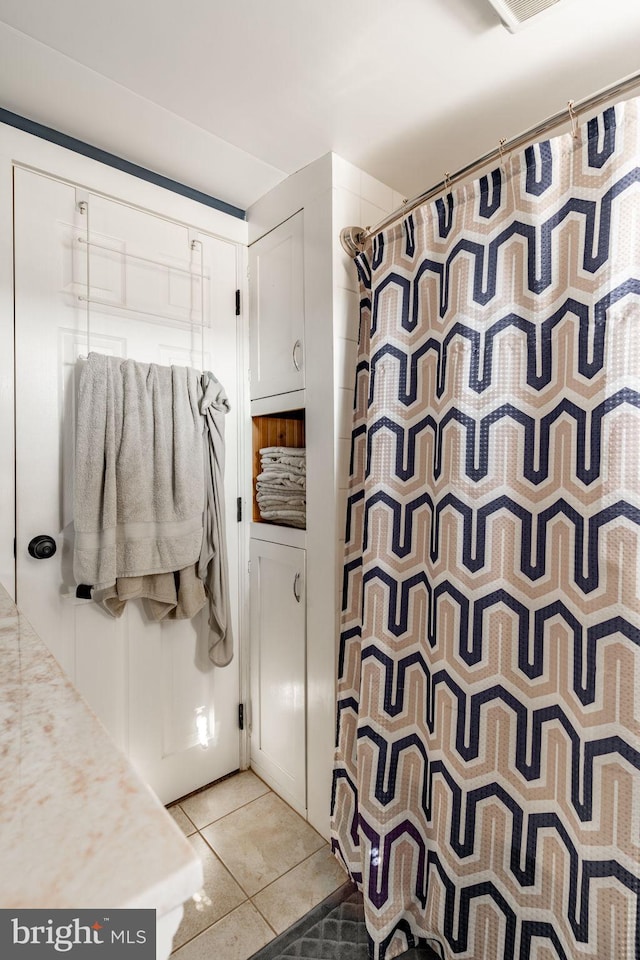 bathroom with tile patterned flooring and walk in shower