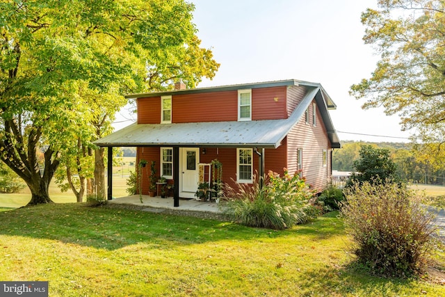 back of house featuring a lawn and a patio area