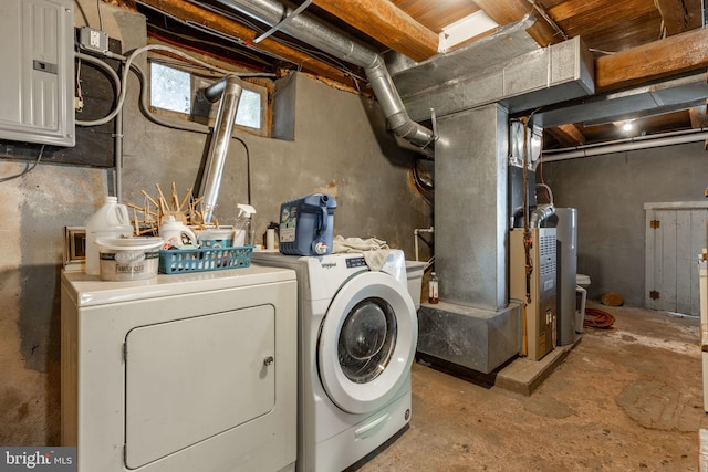 clothes washing area with electric panel, water heater, heating unit, and independent washer and dryer