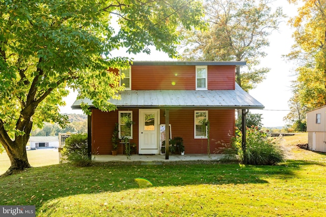 rear view of property featuring a lawn