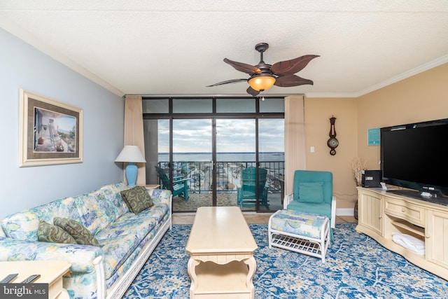 living room with ceiling fan, crown molding, expansive windows, and a textured ceiling