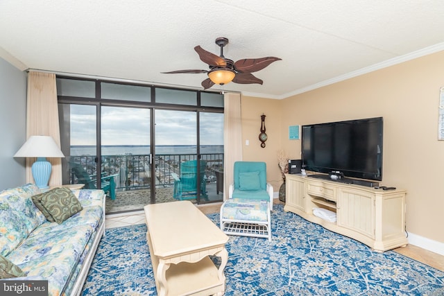 living room featuring tile patterned floors, ceiling fan, crown molding, and expansive windows